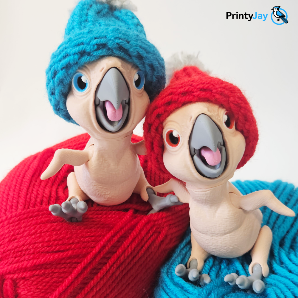 Baby parrot 3D prints wearing knitted beanies sitting on yarn skeins - PrintyJay